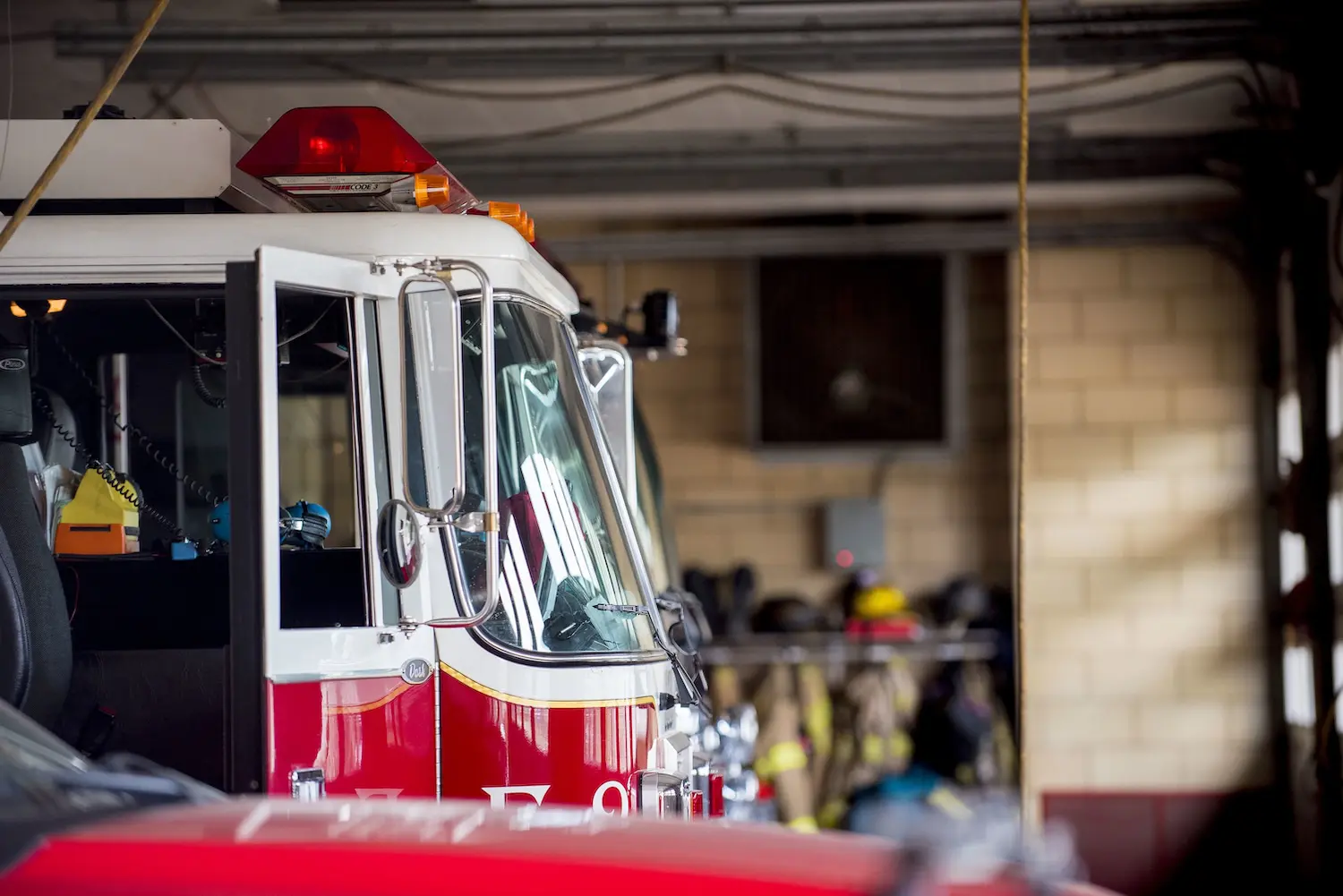 A closeup shot of a firetruck with an open door and a blurred background
